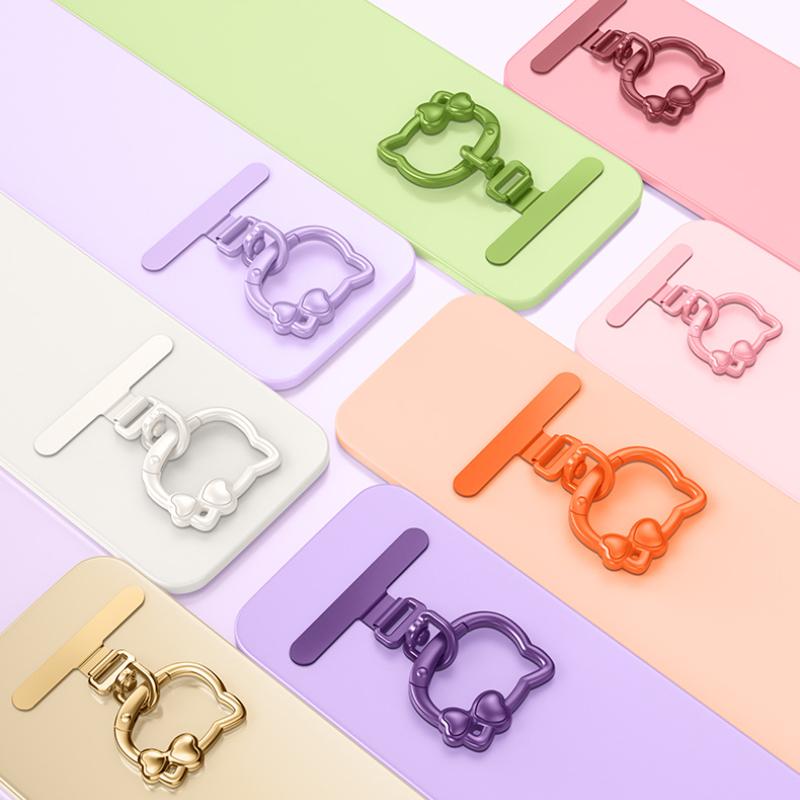 Y087 cat ring buckles in black, silver, gold, rose gold, blue, green, orange, pink, dark purple and wine red laid out with phones