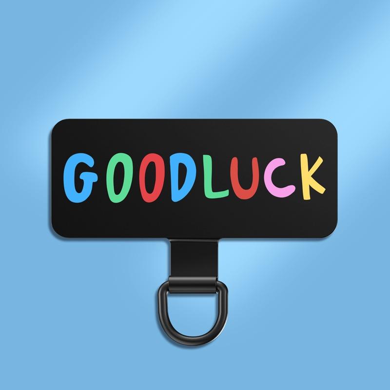 Y143 ultra-thin stainless steel phone tether tab in the Goodluck print with multicoloured lettering on the black plate