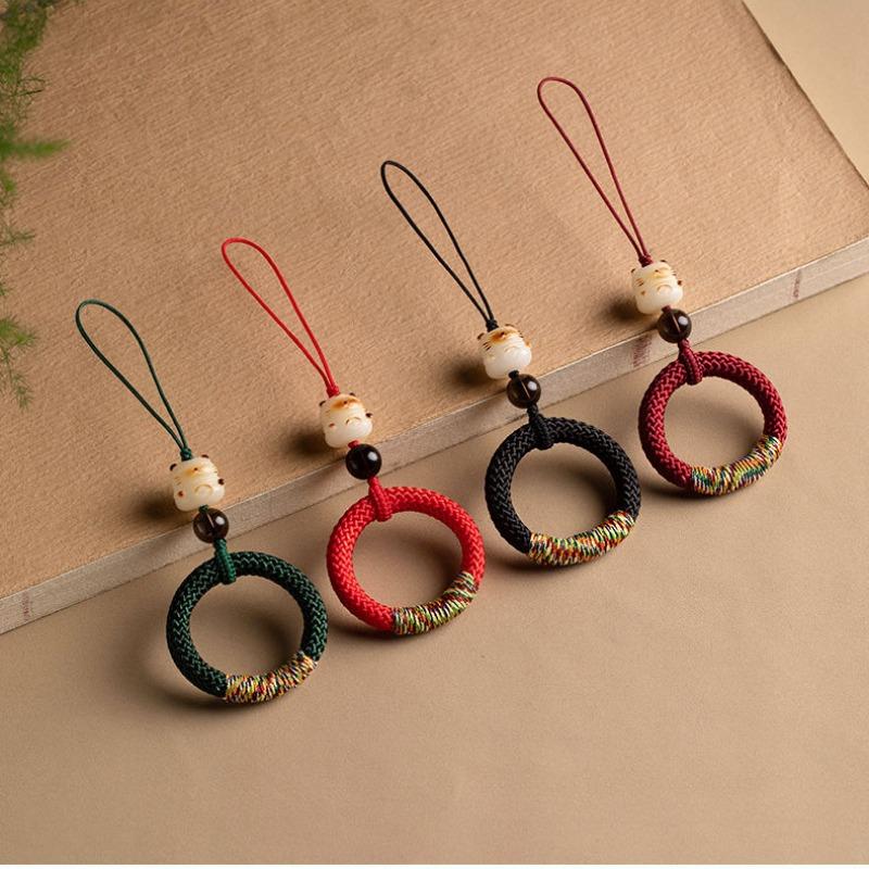 Y290 lucky cat ring straps in dark green, red, black and wine red lined up on a desk