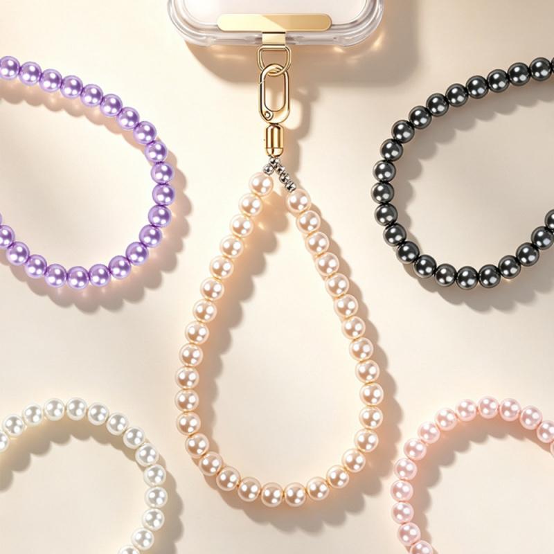Y082 pearl wrist charms in black, light purple, pink, white and champagne laid out with a phone on the gold stepped clip